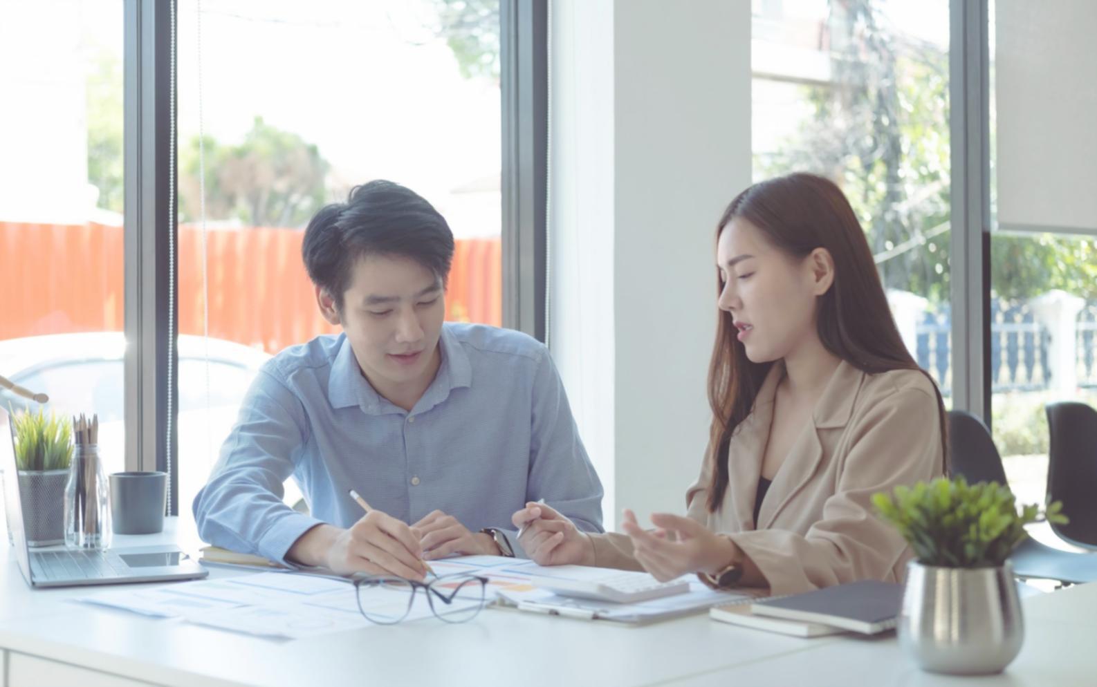 Professional financial planning consultation showing detailed charts and planning documents